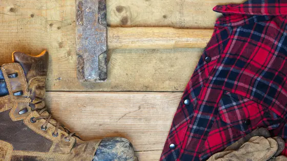 Work boots, gloves and a folded shirt on a plank floor