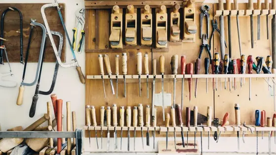 A shadow board of hand tools hung above a workbench