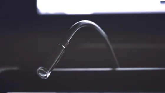 Water arcing from a faucet against a dark background