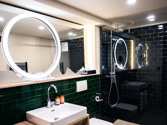 A remodelled bathroom with twin vanities and round mirrors