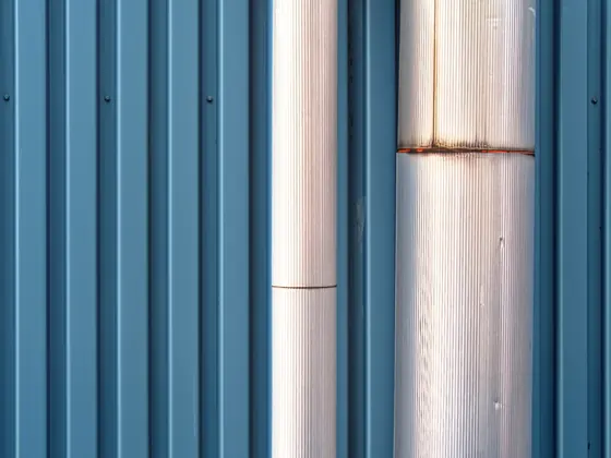A copper pipe run fixed against corrugated cladding