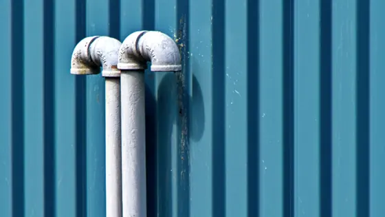 Supply risers running up the outside of a building wall