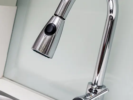 A pull down kitchen faucet over a stainless sink