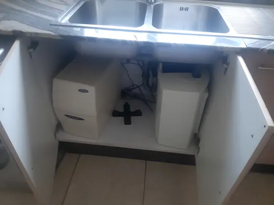 Supply lines and a filter housing in an under sink cabinet
