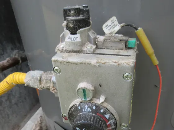 The gas control valve and temperature dial on a storage water heater