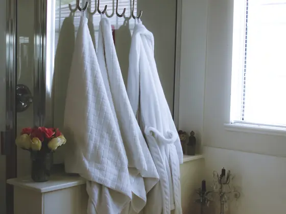 Folded towels and robes hanging in a bathroom